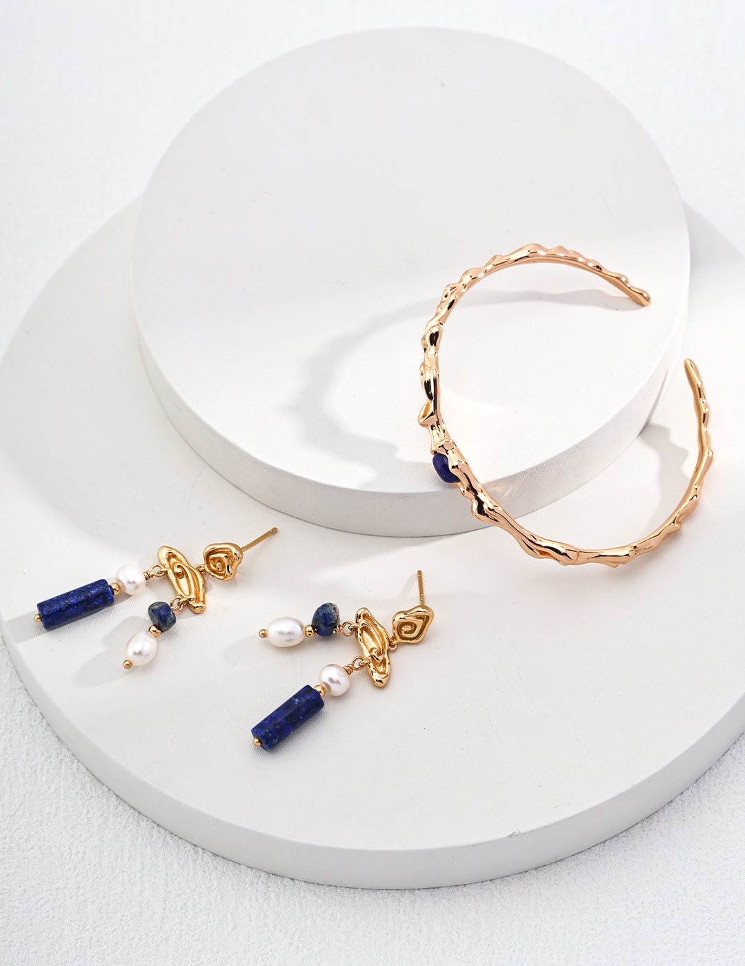 Stunning gold and blue jewelry set on a pristine white background, highlighting the intricate design and color contrast.