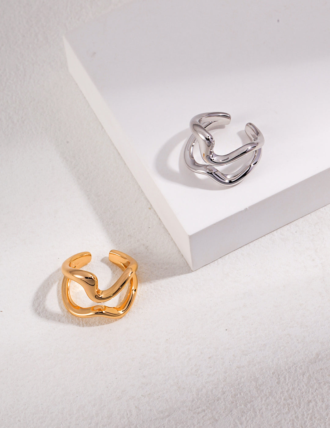  Stylish silver and gold rings featuring intricate double band design on white background.