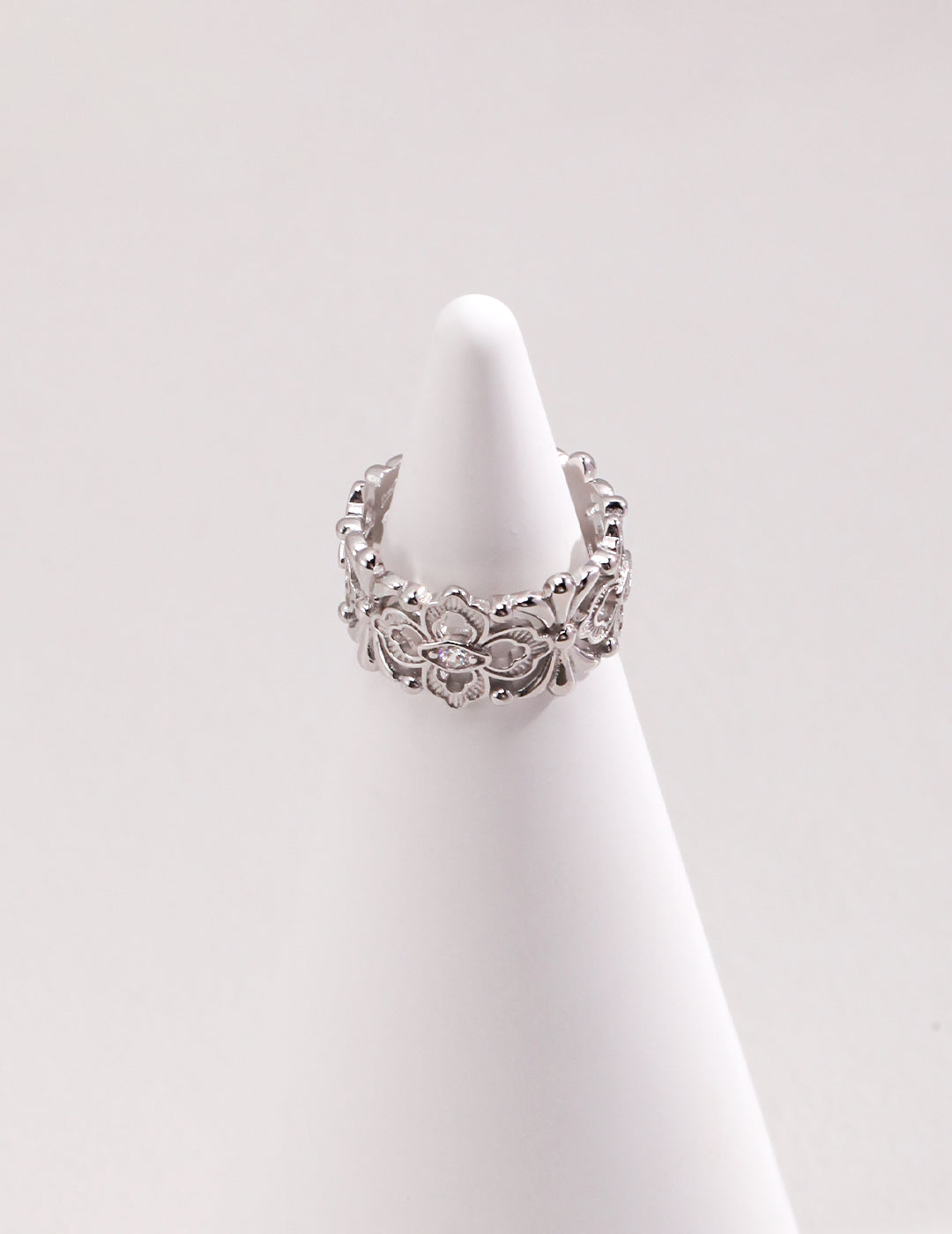 Silver hollow ring with cubic zirconia on white cone.