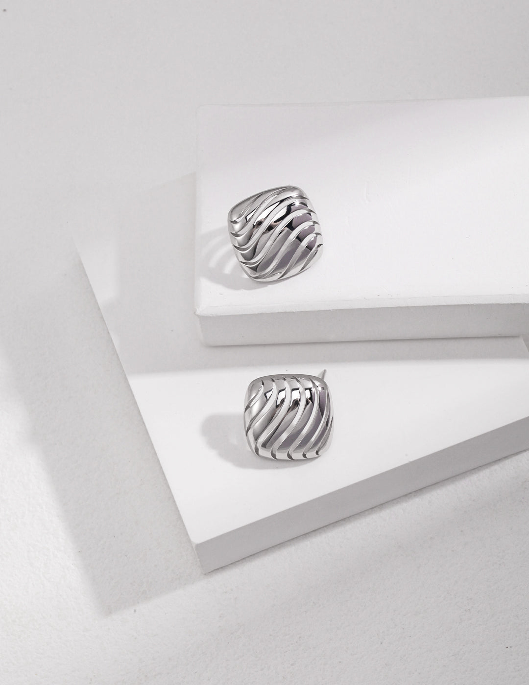 Shiny hollow wave silver rings on white background.