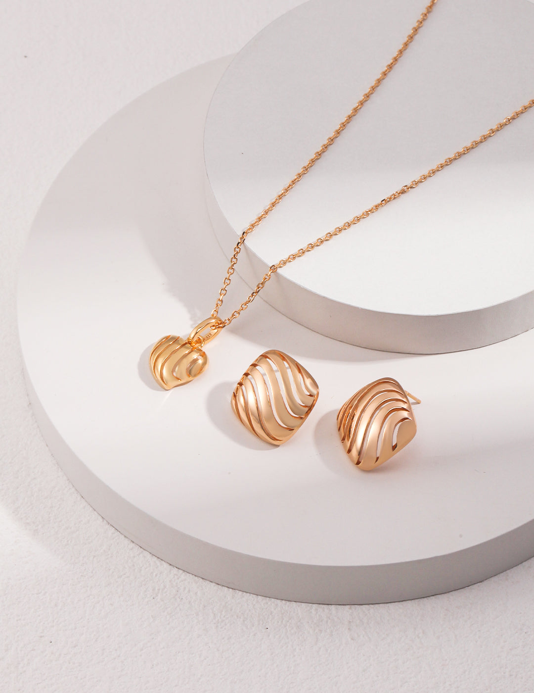 Gold plated necklace and earrings with a beautiful hollow wave pattern design. Perfect for adding elegance to any outfit.