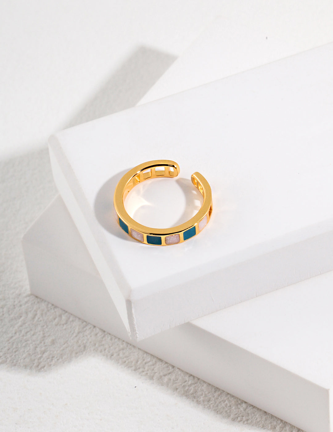 A gold ring with blue and green stripes, showcasing the beauty of gold plated enamel rings.