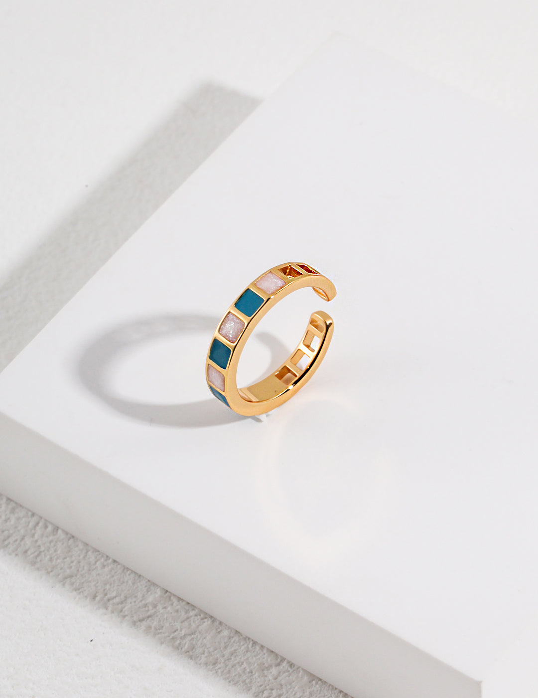 A gold ring with blue and white stones, perfect for adding a touch of elegance to any outfit.