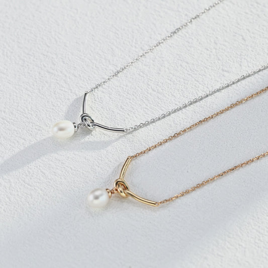 Mezuille's two Love Me Knot Necklaces with pearl pendant, in silver and gold respectively, showing intrinsic craftmanship.